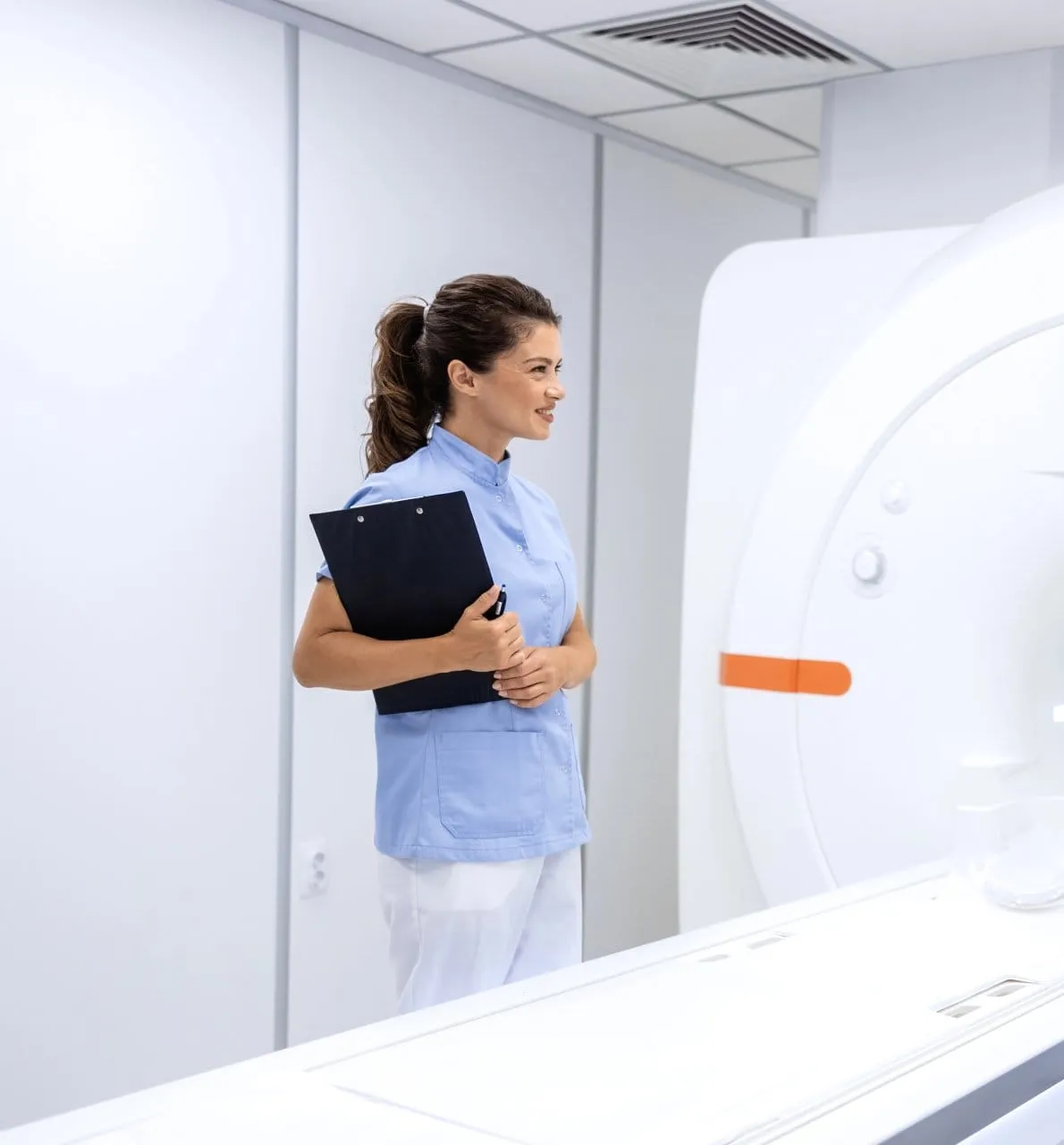 Zorgverlener met een klembord bij de MRI-scanner